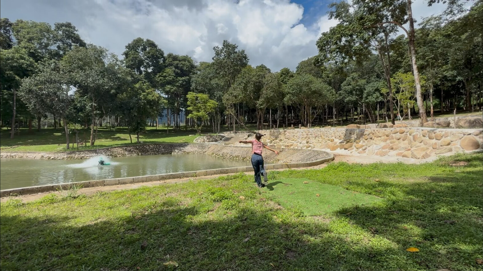 A player throwing across the pond hole beside the stone-wall bank at Rock n' River