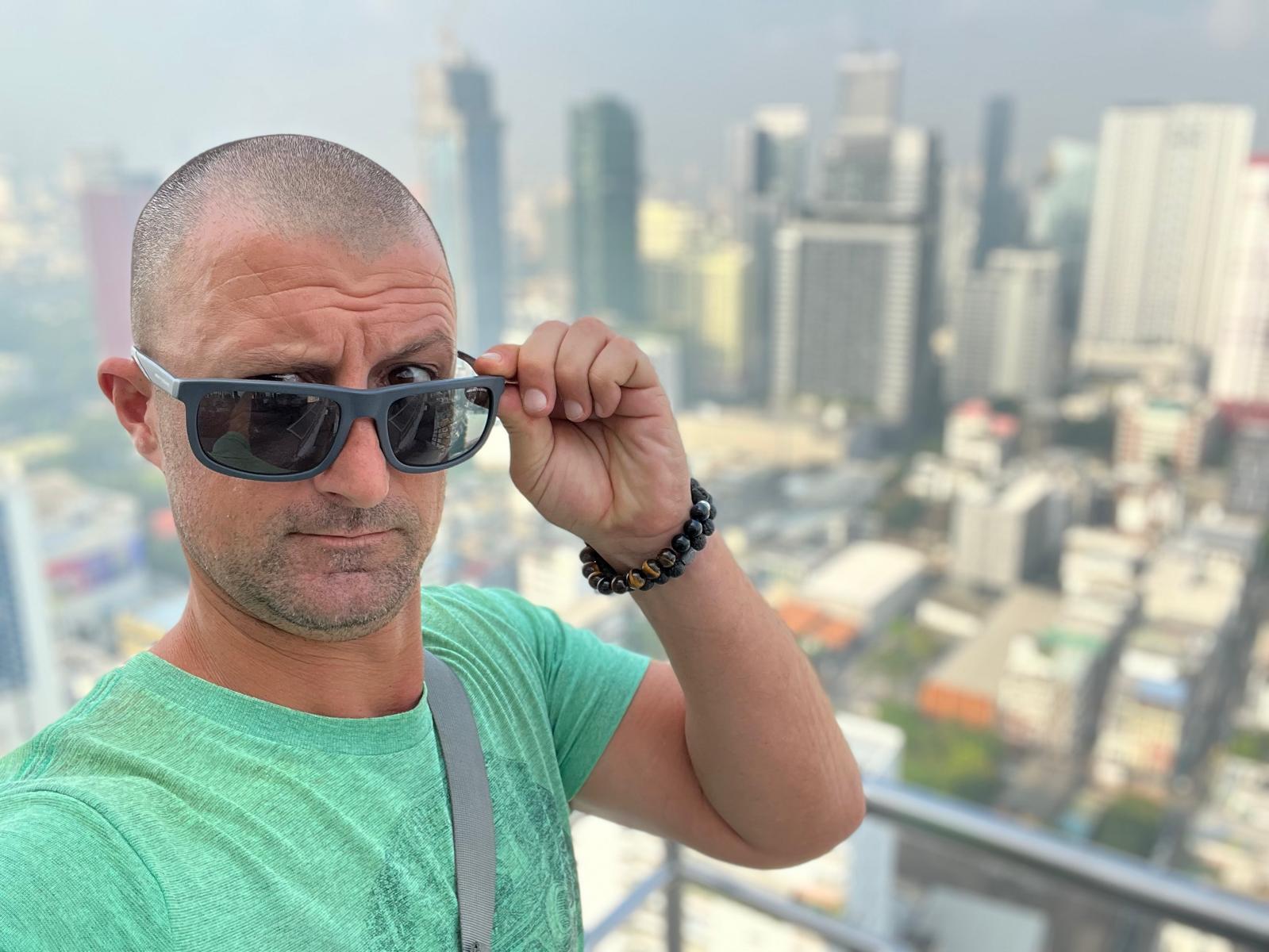 Course designer Danny Diaz in sunglasses with a city skyline behind him