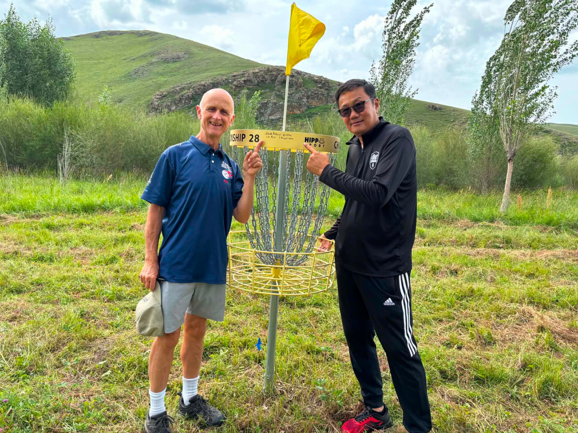 Hall of Famer Derek Robins beside a disc golf basket